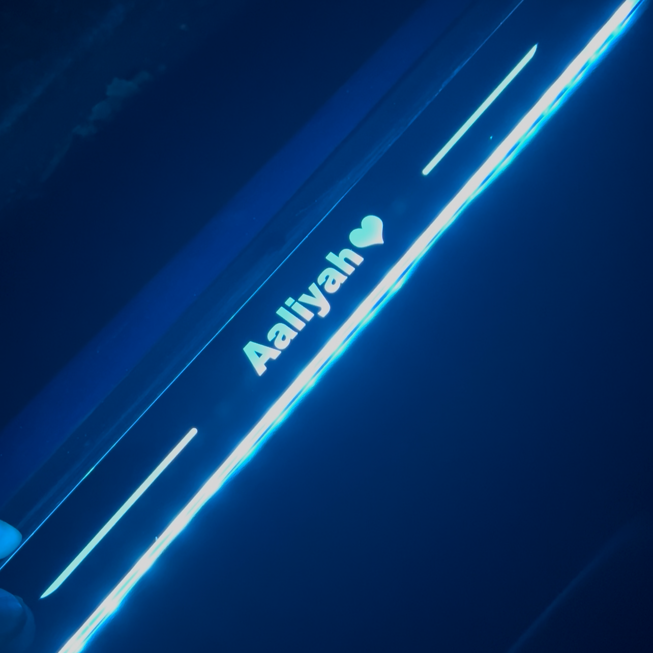 Close-up of a car with 'Aallyah' branding on a dark background